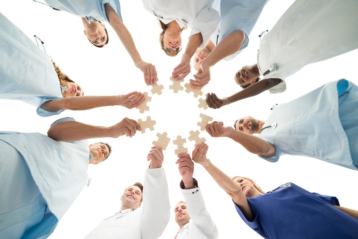 A group of people holding up puzzle pieces.