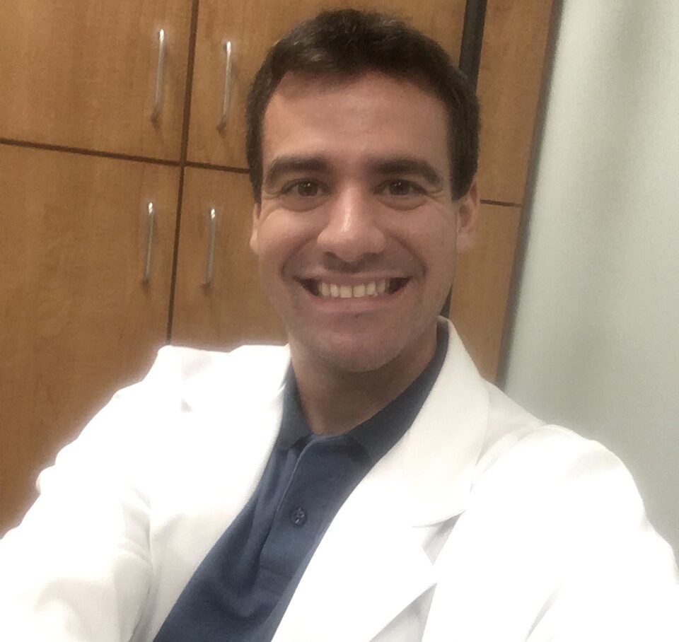 A man in white lab coat smiling for the camera.