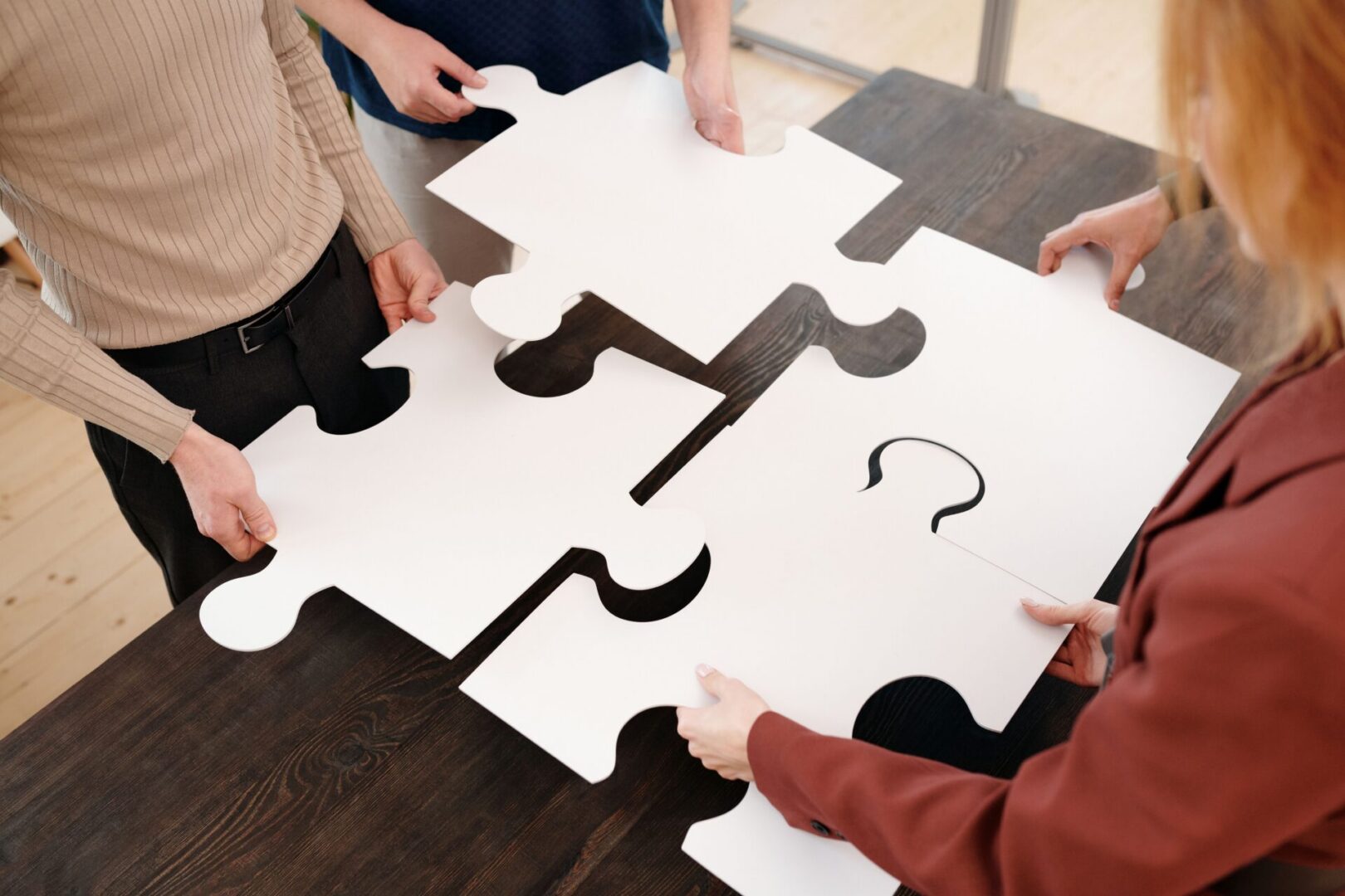 a group of people holding up puzzle pieces.